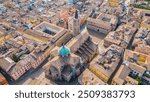 An aerial view of Parma, Italy, showcasing the iconic Cattedrale di Parma and the Battistero di Parma, captured by a drone.  This historic city is known for its rich cultural heritage