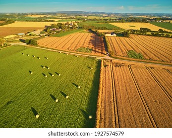 Aerial view of pastures and farmlands in Brittany, France. Beautiful French countryside with green fields and meadows. Rural landscape on sunset