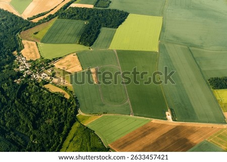 Aerial View of Patchwork Farmland Fields. For illustrating rural agriculture, land use, and countryside planning in educational or commercial contexts.