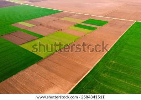 Aerial view of patchwork fields and mosaic cultivated lands on a sunny day. Top view, drone shot. Agro-industrial culture. Various types agricultural cultures. Photo wallpaper. Beauty of earth.
