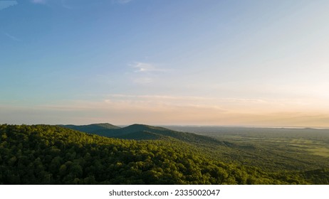 Aerial view of the Peak of the mountain range and tall forest near to the river at summer cloud evening with horizon, yellow color, low height - Powered by Shutterstock