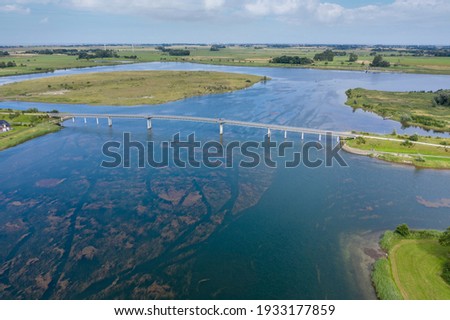 Aerial view with the pedestrian bridge over the lake Wangermeer in Hohenkirchen. Hohenkirchen belongs to the municipality of Wangerland and is located in the region East Frisia in Germany.