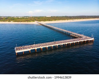 Aerial view pedestrians walking on Palanga pier bridge - famous landmark in summer. Lithuania holiday vacation.