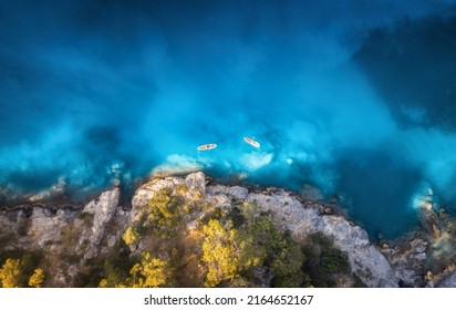 Aerial view of people on floating kayaks on blue sea, rocky coast, trees at sunset in summer. Blue lagoon, Oludeniz, Turkey. Tropical landscape. Sup boards on clear water. Top view of canoe. Tourism - Powered by Shutterstock