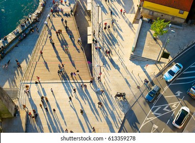 Aerial view of a people walking on the street at sunset