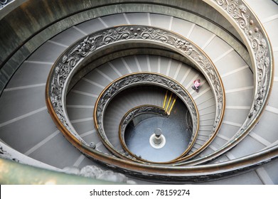 Aerial View Of A Person Human Scale Walking Down Bramante Staircase, A Double Helix Spiral Staircase Located Inside The Vatican Museums At The Vatican City State In Rome, Italy.