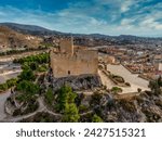 Aerial view of Petrer, medieval town and hilltop castle with restored tower and battlements near Elda Spain