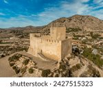 Aerial view of Petrer, medieval town and hilltop castle with restored tower and battlements near Elda Spain