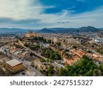 Aerial view of Petrer, medieval town and hilltop castle with restored tower and battlements near Elda Spain