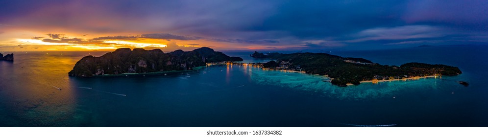 Aerial view of Phi Phi, Maya beach with blue turquoise seawater, mountain hills, and tropical green forest trees at sunset with Andaman sea in summer, Thailand in travel trip. Nature. Panorama