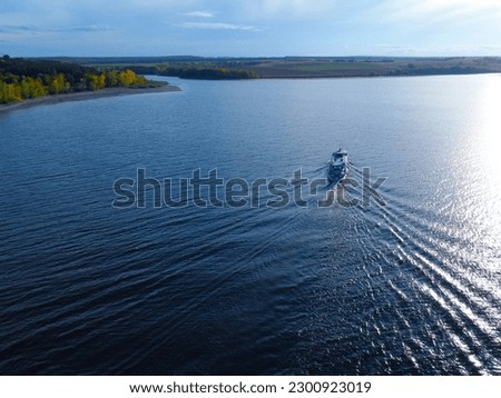 Aerial View photo. Passenger boat sailing on the estuary. Crossing the river in a small ship. Water transport and passenger transportation in the Russian.