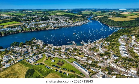 Aerial view of a picturesque coastal town with a river, surrounded by lush green hills and farmland. In Cornwall, UK. - Powered by Shutterstock