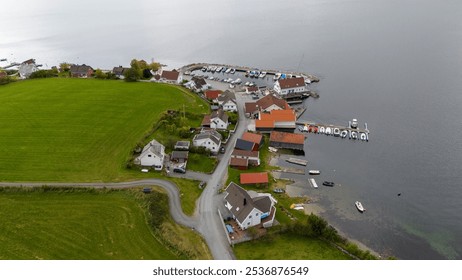 Aerial view of a picturesque coastal village with houses, green fields, and a marina. The landscape features residential homes, trees, and a body of water, showcasing the beauty of rural living. - Powered by Shutterstock