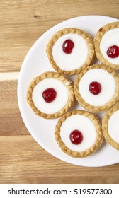 Aerial View Of A Plate Full Of Freshly Baked Bakewell Tarts On A Wooden Kitchen Counter Top Background