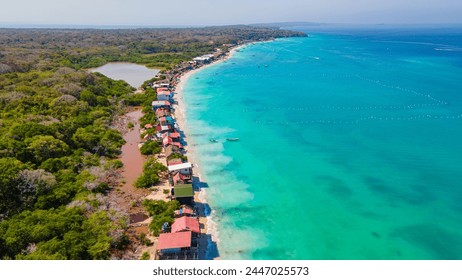 Aerial view of Playa Blanca, Baru, showcasing the vibrant turquoise waters, lush greenery, and colorful beachfront properties - Powered by Shutterstock