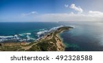 Aerial view of the Point Nepean National Park on a bright sunny day with a cargo ship passing through The Rip into Port Phillip Bay. Melbourne, Victoria, Australia.