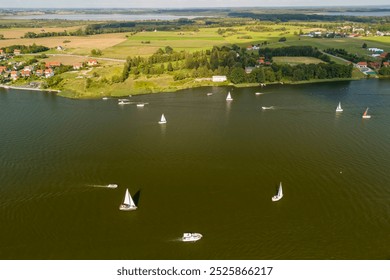 Aerial view of Mikołajki, Poland, showcasing sailing boats on a serene lake surrounded by lush greenery and idyllic scenery. - Powered by Shutterstock