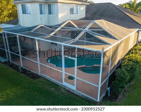 An aerial view of pool screen enclosure surrounded by trees