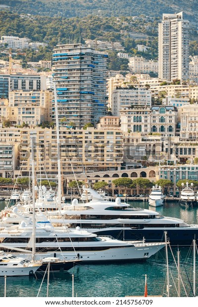 Aerial view of port Hercules at\
sunset, mega yachts are moored in marina near yacht club of Monaco,\
view of city life from old town, a lot of mega yachts and\
boats