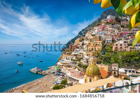 Aerial view of Positano with comfortable beach and blue sea on Amalfi Coast in Campania, Italy. Amalfi coast is popular travel and holyday destination in Europe. Ripe yellow lemons in foreground.