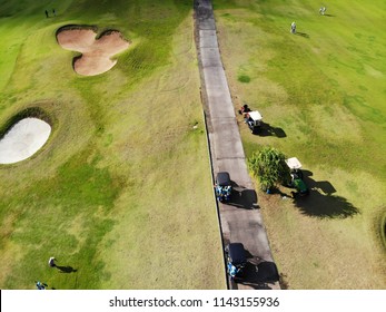 Aerial view of pound on golf course with player, footpath on golf course, playr enjoying the game under sun, golf field ariel view, Bali, Indonesia