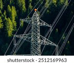 Aerial view of power line pylon in alpine forest in Switzerland. Electric current distribution with power grid.