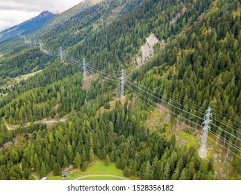 Aerial View Of Power Line And Pylon In Alpine Valley Of Goms In Switzerland. Power Grid Through Alps. 