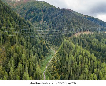 Aerial View Of Power Line And Pylon In Alpine Valley Of Goms In Switzerland. Power Grid Through Alps. 