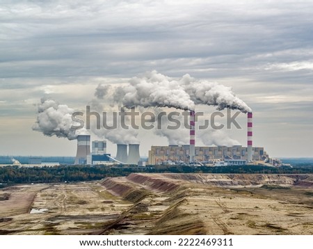 Aerial view of power plant and open-cast coal mine in Belchatow under moody cloudy sky, Poland