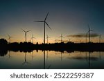 Aerial view of powerful Wind turbine farm for green energy production on beautiful sky, good environment . Wind power turbines generating clean renewable energy for sustainable development ecosystem.