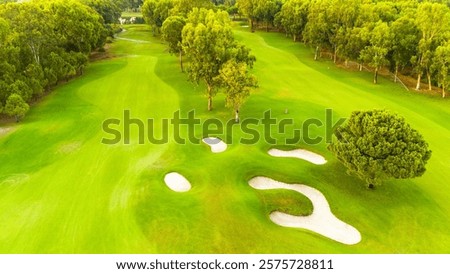 An aerial view of a pristine golf course with sand traps and lush greenery