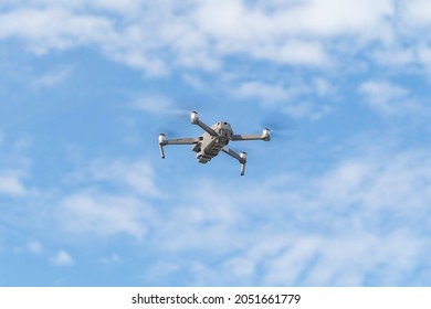 Aerial View Of A Professional Drone With Propellers Flying With Camera And Blue Sky In Digital Technology Concept. An Electronic Gadget Equipment. A Small Plane Or Aircraft.