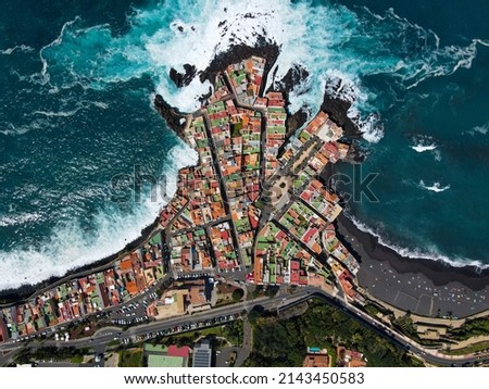 Aerial view of Punta Brava, near the town of Puerto de la Cruz on the island of Tenerife, Canary Islands, Atlantic Ocean, Spain. Drone colorful houses and black lava rocks in small fisherman village.
