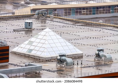 Aerial view pyramid-shaped skylight window flat roof with air conditioners top modern apartment building. Urban development and sustainable lifestyle concept. - Powered by Shutterstock