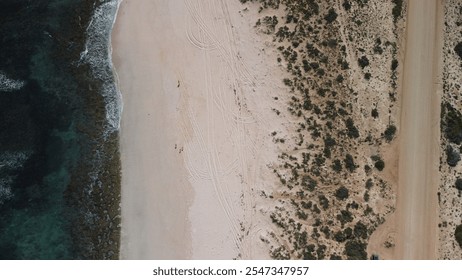 Aerial view of Quobba Station cliffs, Western Australia. Ocean waves crashing on sandy beach, clear blue water, and wide sky. Stunning coastal landscape captured with drone photography. - Powered by Shutterstock