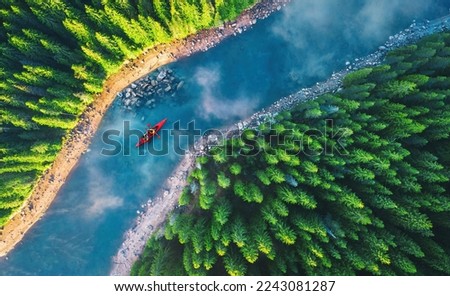 Aerial view of rafting boat or canoe in mountain river and forest. Recreation  camping and sport lifestyle