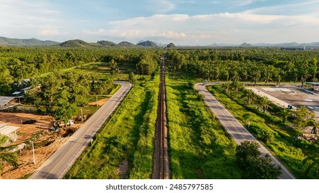 aerial view Railway tracks in the suburbs. The railway line crosses the river. Train transportation. Railway tracks and road from above that is a long way Through natural areas in rural areas - Powered by Shutterstock