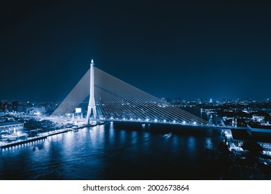 Aerial view of Rama 8 Bridge and Chao Phraya River in structure of suspension architecture concept, Urban city, Bangkok skyline. Downtown area at night, Thailand.