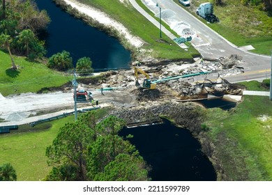 Aerial view of reconstruction of damaged road bridge destroyed by river after flood water washed away asphalt. Rebuilding of ruined transportation infrastructure - Shutterstock ID 2211599789