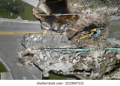 Aerial View Of Reconstruction Of Damaged Road Bridge Destroyed By River After Flood Water Washed Away Asphalt. Rebuilding Of Ruined Transportation Infrastructure