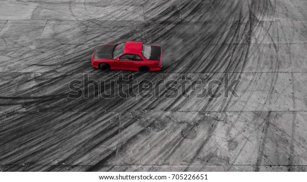 Aerial view Red race car drifting on race\
track, Abstract texture and background black tire tracks skid on\
asphalt road, Wheel tire tracks background, Car tire track skid\
mark on race track\
background