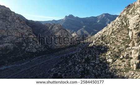 Similar – Image, Stock Photo Sunlit peak of a massive rock formation with the Caminito del Rey path along the side in Malaga