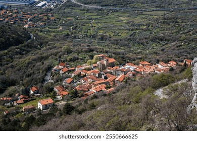 Aerial view of the red-roofed town of Sant'Antonio in Bosco (Boršt), near Trieste, Italy, captured from Via Ferrata Rose d'Inverno, showcasing lush greenery, scenic landscapes, and rural charm. - Powered by Shutterstock