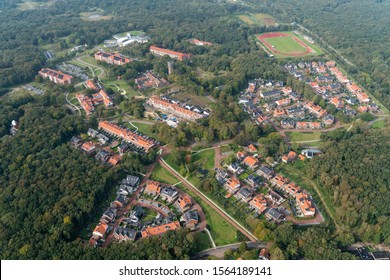 Aerial view of residential area in Duin en Bosch area, Castricum, Holland. New houses built in thirties style with orange and black roofing surrounded by nature, park and trees.
