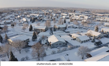 Aerial View Of Residential Houses, Condo, Townhouses Covered Snow At Winter Season. Establishing Shot Of American Neighborhood, Suburb At Wintertime.  Real Estate, Midwest, Sunny Morning 