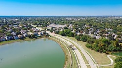 Aerial View Residential Neighborhood With Grapevine Lake In Horizontal Line. Row Of Upscale Two Story Suburban Residential Houses Near Local Pond In Flower Mound, Texas, America