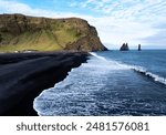 Aerial view of Reynisfjara black sand beach and sea stacks in Iceland.