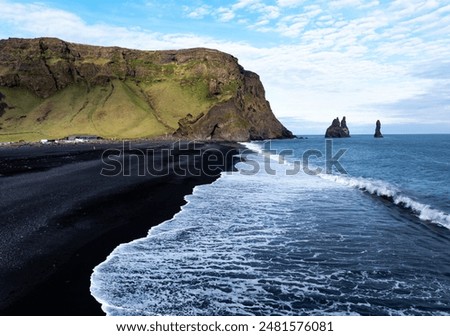 Aerial view of Reynisfjara black sand beach and sea stacks in Iceland.