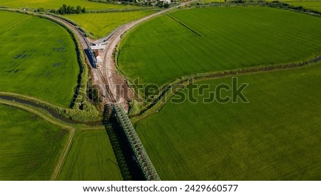 aerial view of a rice field with the train line cutting through the image