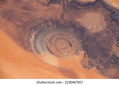 Aerial view of Richat Structure in Mauritania. Also called Guelb er Richât in Arabic Qalb ar-Rīšāt.  Digitally enhanced. Elements of this image furnished by NASA. - Shutterstock ID 2230487857